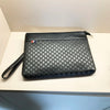 A black quilted PU leather clutch bag with a flap and a small leather strap resting on a white surface.