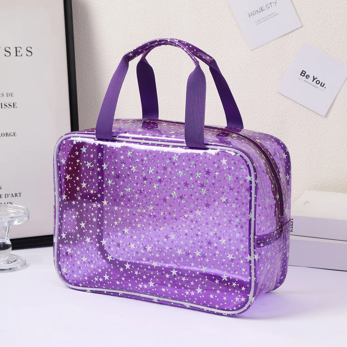A purple clear waterproof makeup organizer bag with purple handles resting on a white surface.