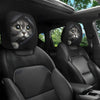 Two black car headrest covers featuring a cat face design are shown in a vehicle interior.