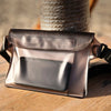A sleek, metallic pink waterproof mobile phone pouch resting on a wooden surface next to a spool of twine.