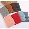 Collection de porte-passeport en cuir imperméable dans diverses couleurs : marron, gris, noir et rouge.