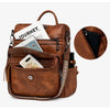A brown retro PU leather travel backpack filled with various accessories and a white notebook.