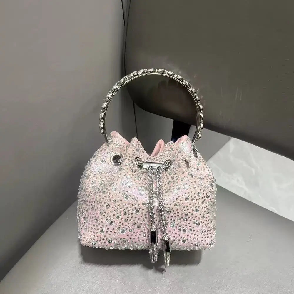 A pink crystal-embellished evening clutch with a silver chain and a matching circular mirror.