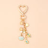 Gold heart-shaped keychain featuring a seashell, starfish, and pearl accents.