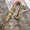 Gold-cremiges kariertes Stoff-Lanyard mit Schlüsselring auf texturierter grauer Oberfläche