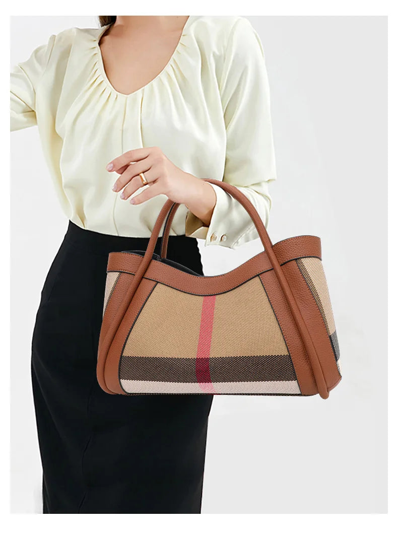 Eine Frau hält eine karamellfarbene Karom-Kuhschwarte-Tasche in Beige- und Brauntönen vor einem weißen Blusen und einem schwa