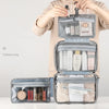 A gray toiletry bag with a hanging hook is shown open, displaying various skincare and grooming products.