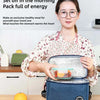 Eine Frau hält eine isolierte Thermotasche mit einer gesunden Mahlzeit, die sie für Picknicks und Arbeit demonstriert.