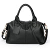 Black soft leather tote bag with a padded flap and adjustable shoulder strap.