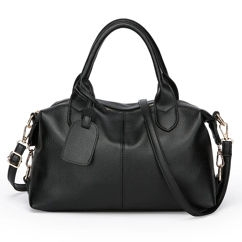 Black soft leather tote bag with a padded flap and adjustable shoulder strap.