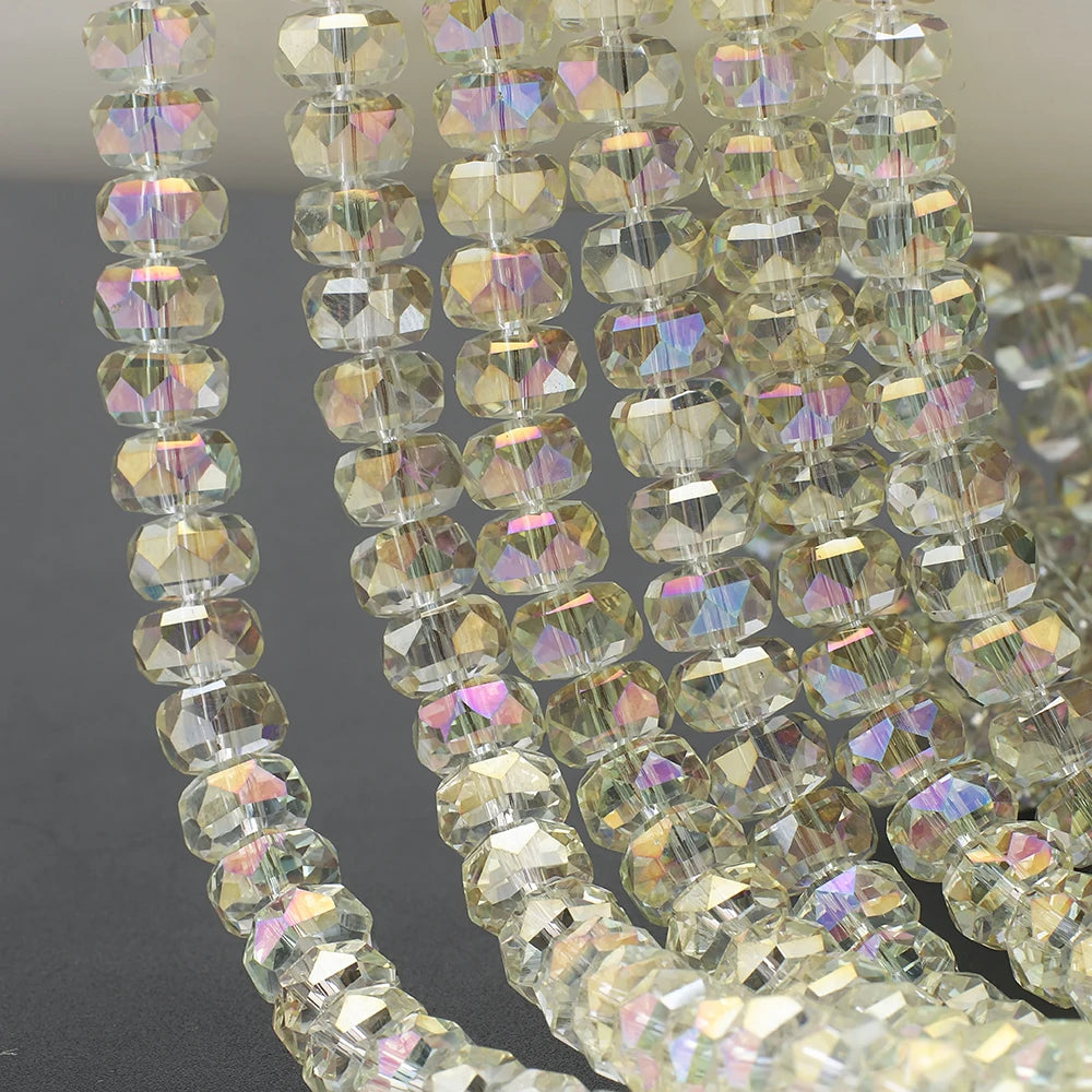 A close-up of clear, faceted crystal glass beads in a wheel shape strung together for jewelry making.