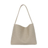 A beige woven straw bucket shoulder bag with a long strap.