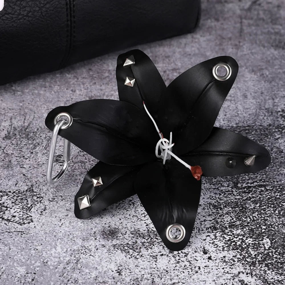 A black leather flower shaped like a Phalaenopsis orchid is attached to a silver keyring.