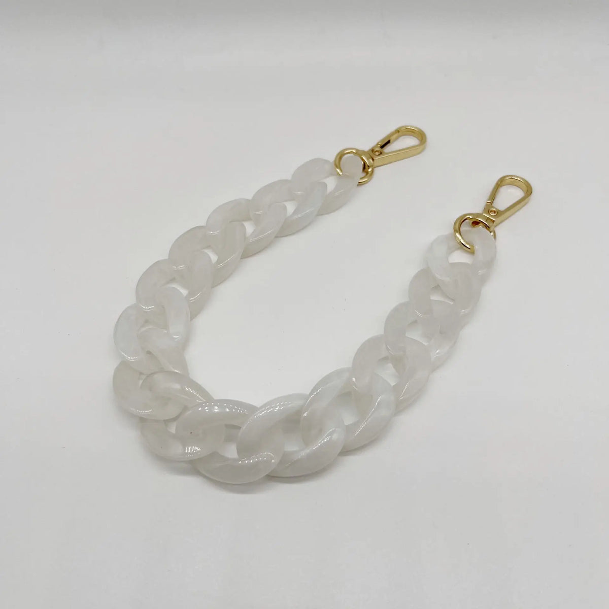 A white acrylic chain bracelet with gold-colored clasps.