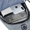 A gray casual chest bag with a zippered pocket containing a silver smartphone and a notebook.
