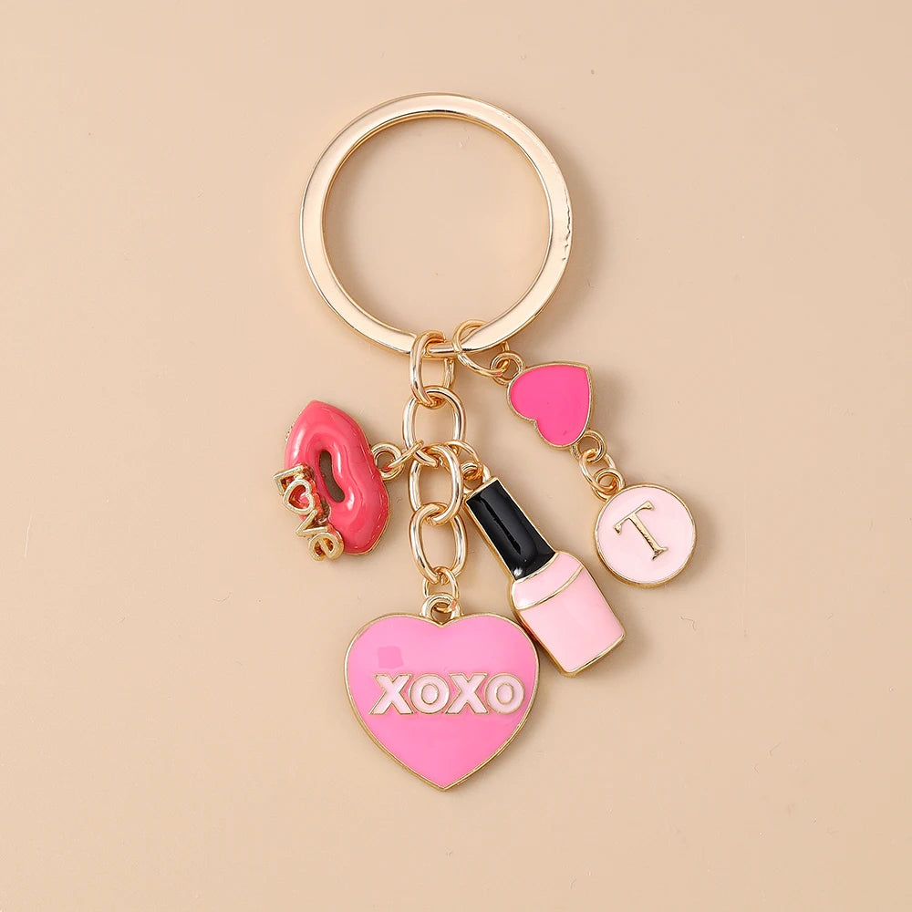 Gold-toned enamel heart keychain with a pink liquid bottle charm and an XOXO heart charm
