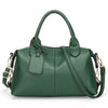 A dark green soft leather tote bag with a padded flap and adjustable shoulder strap.