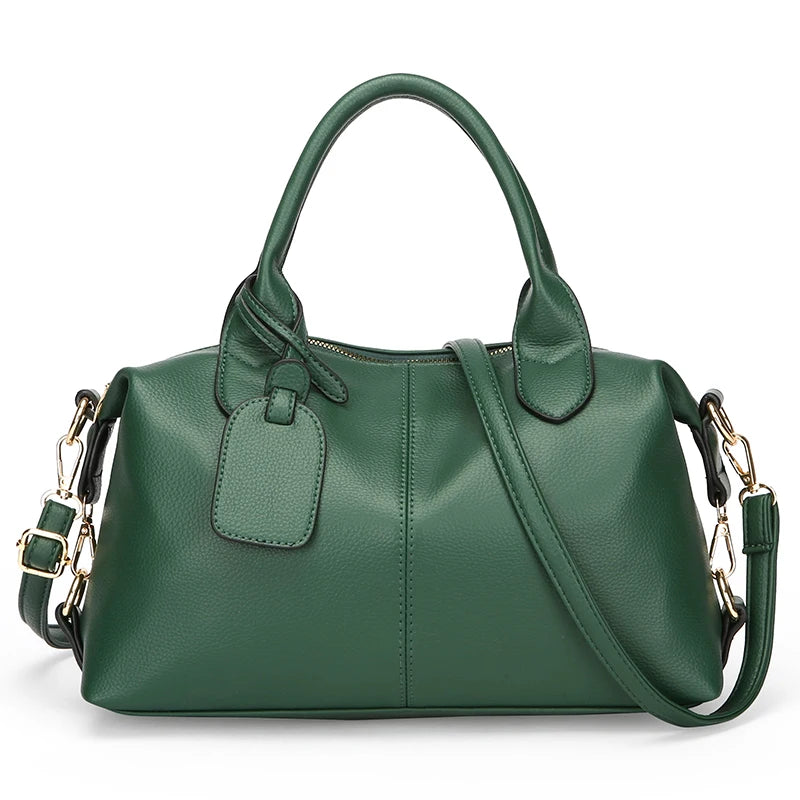 A dark green soft leather tote bag with a padded flap and adjustable shoulder strap.