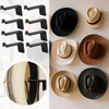 A collection of black and natural fiber magnetic wall hooks for hanging hats and accessories.