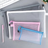 Clear mesh zipper pouches in white, pink, and blue for storage.
