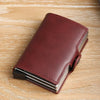 A dark burgundy leather double layer ID card holder wallet resting on a light wooden surface.