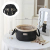 Black instant-open flat lay makeup organizer bag with a drawstring closure displayed on a white table.