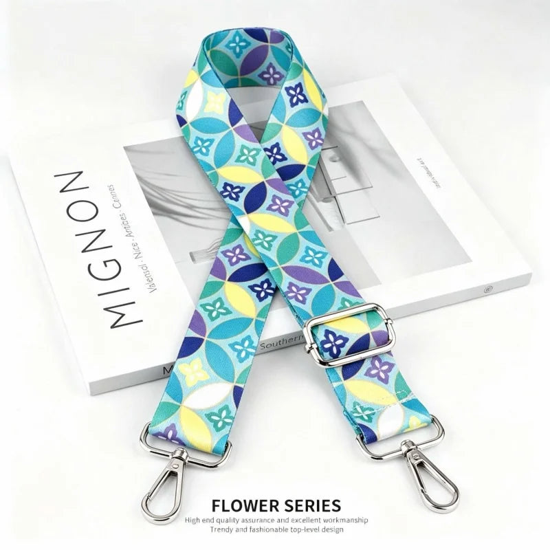 A blue and yellow patterned nylon shoulder strap for bags and purses displayed next to its packaging.