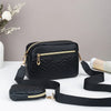 Schwarze gesteppte Crossbody-Tasche mit goldfarbenen Beschlägen auf weißem Untergrund.