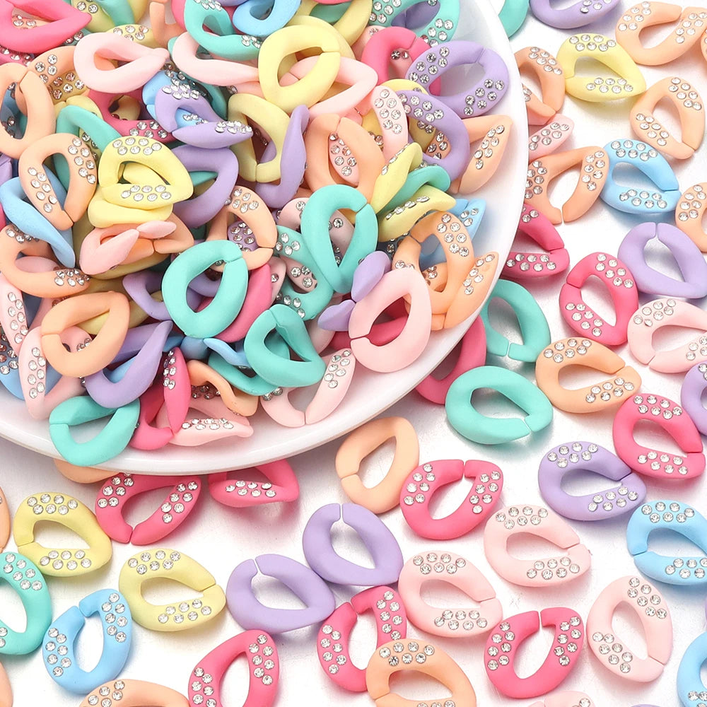 A pile of colorful acrylic link chain connectors in various pastel shades for DIY jewelry making