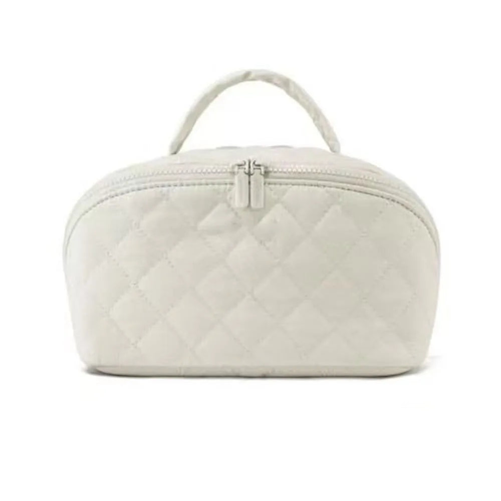 A white lay-flat water-resistant makeup organizer bag with a quilted texture and a zippered top.