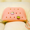 A pink silicone coin pouch with drainage holes resting on a light yellow fabric.