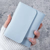A hand holds a light blue slim multi-functional card wallet for students.