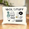 A white zippered pouch with black text reading HAIR STUFF is displayed on a wooden surface.