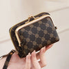 A hand holds a black quilted fashion print accordion card holder wallet with gold hardware.