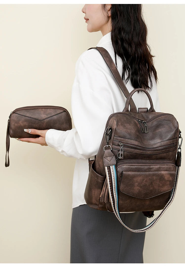 A woman holds a brown retro PU leather travel backpack with a tassel detail.