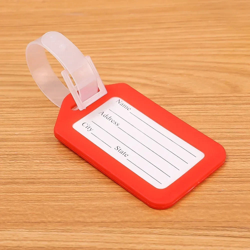 An orange luggage tag with a white label for name, address, and city/state, attached to a clear plastic strap.