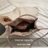 Bolso de seda jacquard rosa claro retro abierto, mostrando su forro interior sobre una superficie blanca.