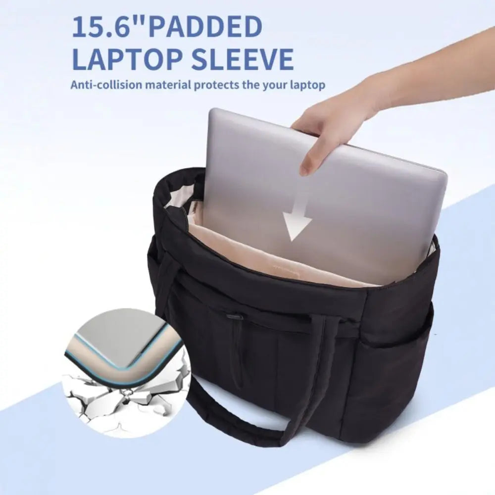 A hand is placing a silver laptop into a black padded laptop sleeve or tote bag.