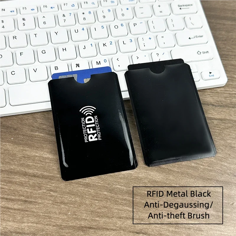 Black RFID metal anti-degaussing anti-theft brush card sleeves resting on a wooden surface.