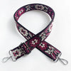 A patterned magenta and white floral jacquard strap for a crossbody bag.