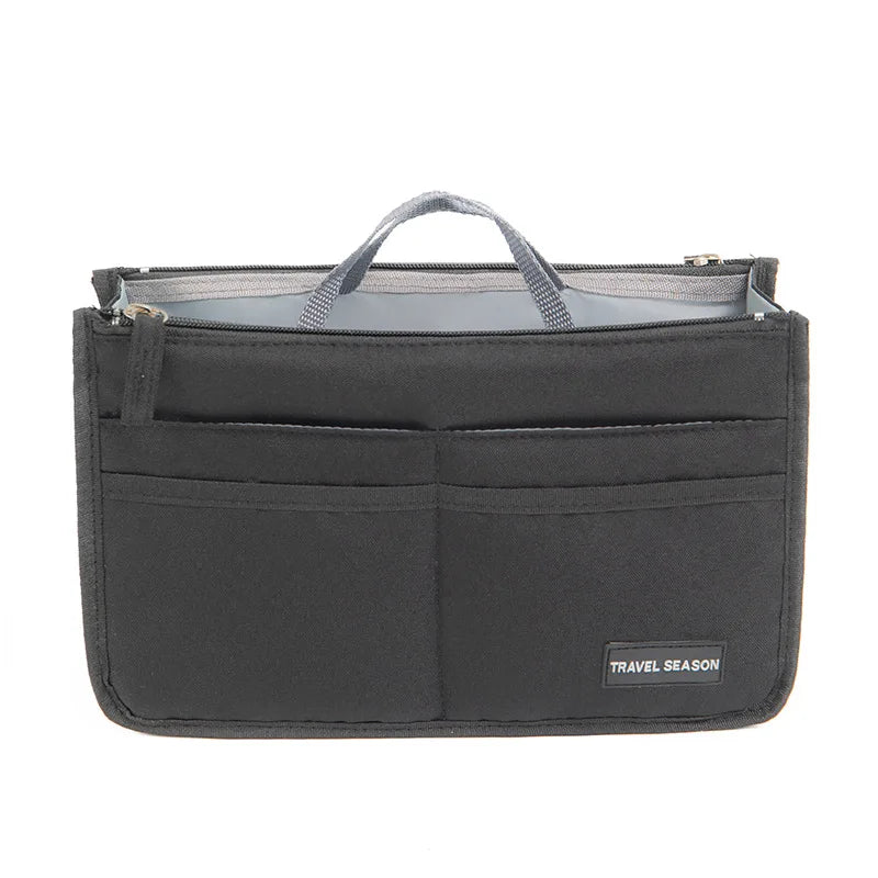 A black handbag organizer insert with a gray lining and a handle.