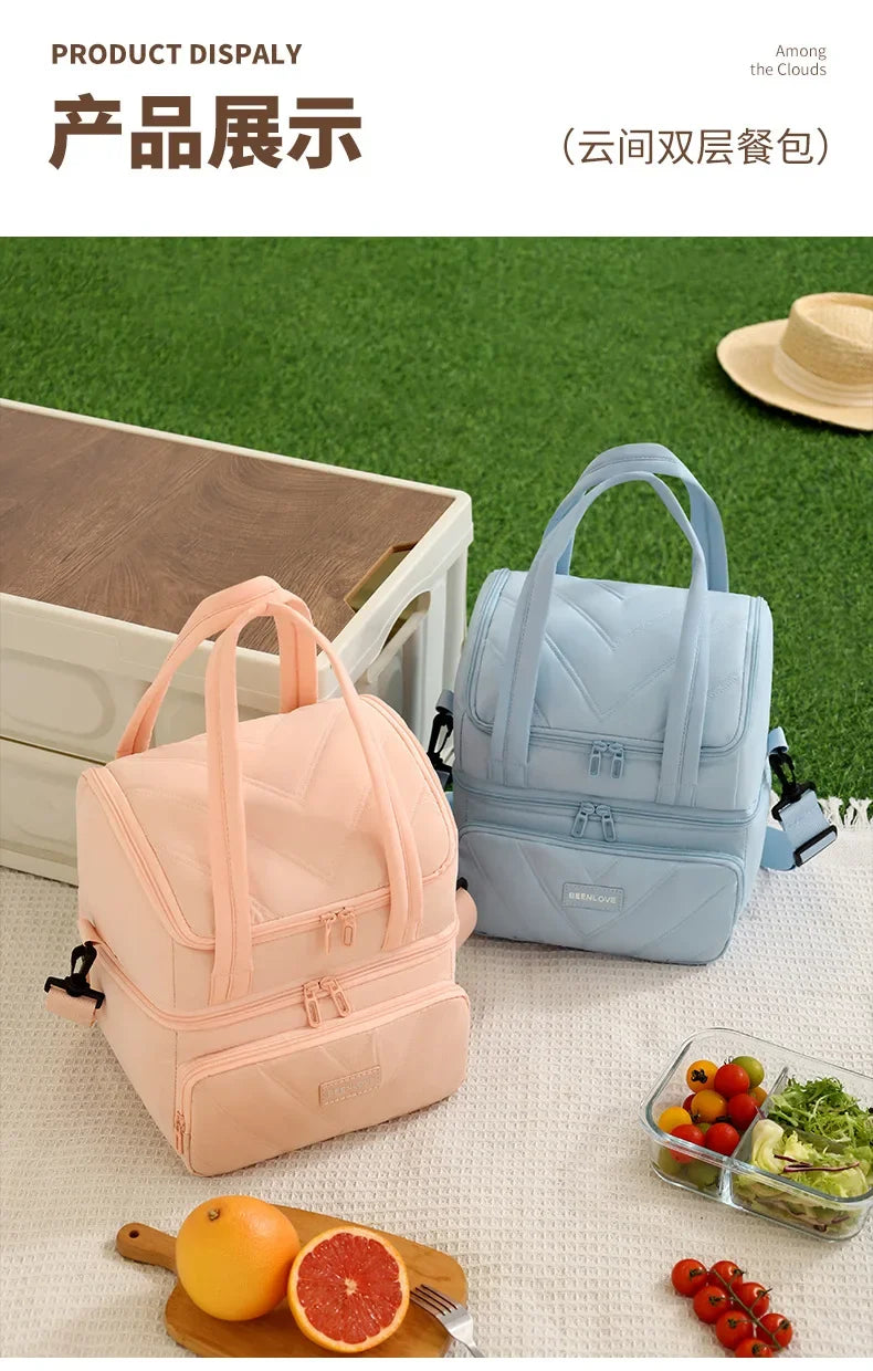 A pink and light blue double-layer insulated lunch bag displayed on a white surface with fruit.