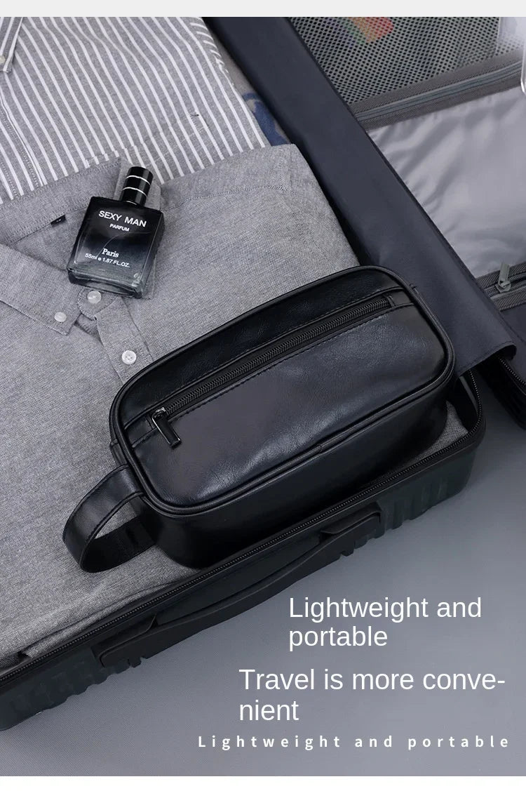 A black leather travel cosmetic bag is shown resting on a gray fabric, next to a perfume bottle.
