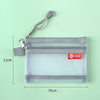A gray double-layer zipper pouch with a clear plastic window and a silver clip is shown against a light green background.