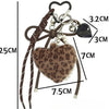 A brown leopard print plush heart pendant keychain with a black charm and pearl beads.