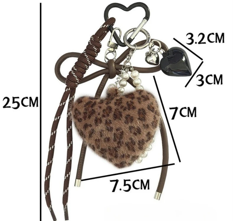 A brown leopard print plush heart pendant keychain with a black charm and pearl beads.