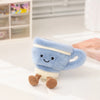 A soft blue cartoon character plush toy resembling a cup with brown paws sitting on a white surface.