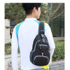 A man wearing a white shirt and jeans is carrying a black nylon chest sling bag outdoors.