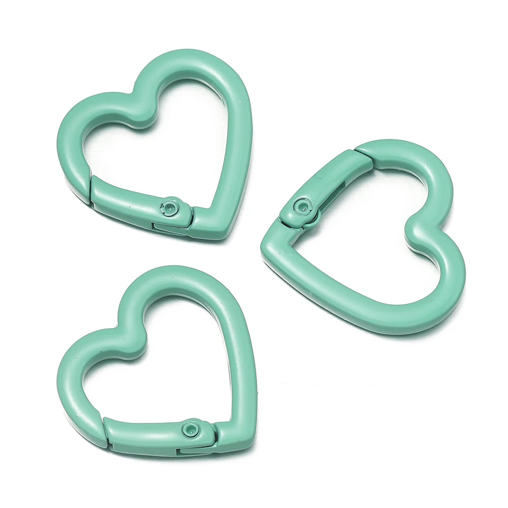 Three heart-shaped metal spring clasps in a mint green color shown separately.