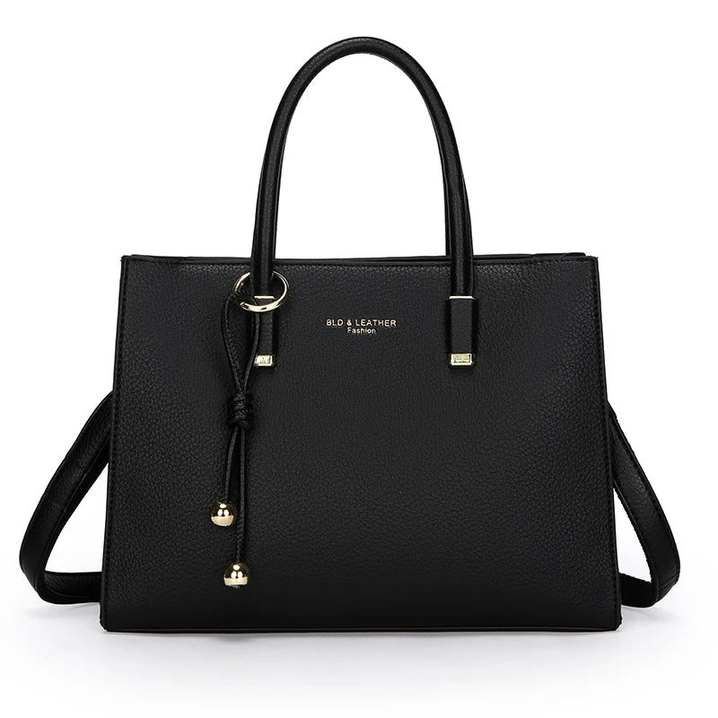 Schwarze Leder-Tasche mit goldfarbenen Beschlägen, Top- und Schulterriemen.